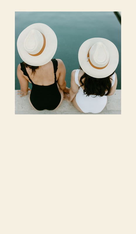 Two girls sitting on a poolside with a Sol Authentica Panama Hats