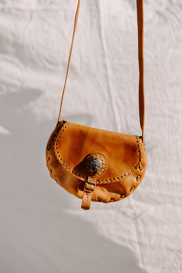 Crafted by expert artisans in Panajachel, this camel leather saddlebag features an adjustable strap and external zipper for secure storage.