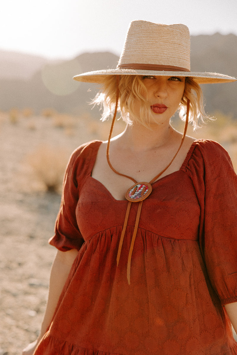 Each Josefina palm hat features a one-of-a-kind upcycled textile fastener and leather chin strap for outdoor events.