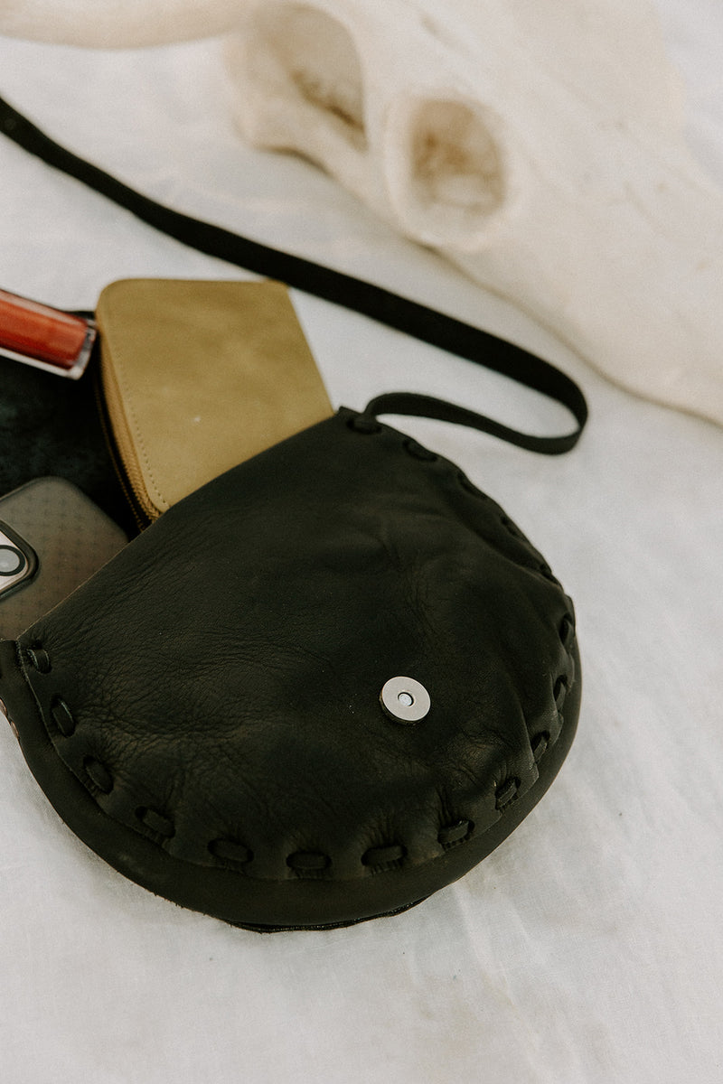 Timeless black leather saddlebag with jade stone, symbolizing good health and lasting durability