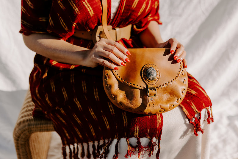 Sustainably produced camel leather saddlebag with jade stone, combining traditional Guatemalan craftsmanship with modern functionality.